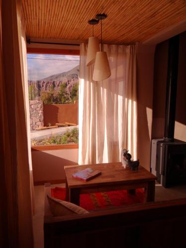 a room with a table and a window with a view at Tierra Quebrada Cabañas in Purmamarca