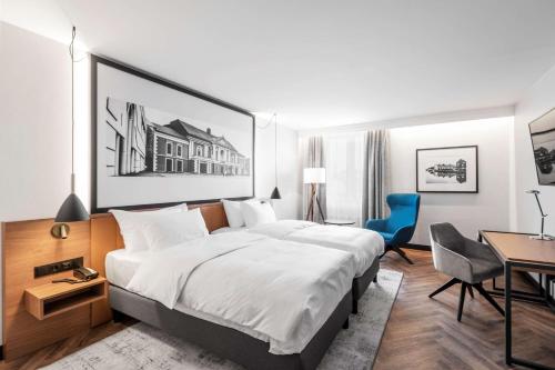 a hotel room with a large bed and a desk at MERCURE KLAIPEDA CITY HOTEL, Meetings, Events, Restaurant & Bar - Accor Group, Pet Stay FREE in Klaipėda
