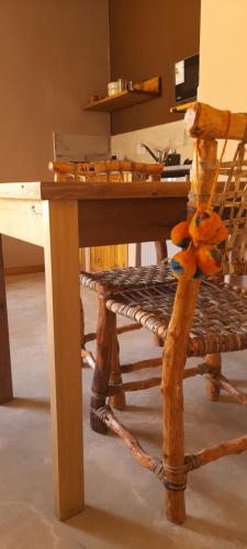 a wooden table and a chair with a stuffed animal on it at Tierra Quebrada Cabañas in Purmamarca