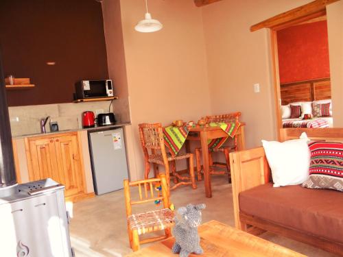 a living room with a kitchen and a dining room table at Tierra Quebrada Cabañas in Purmamarca