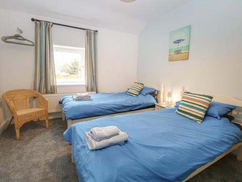 - une chambre avec deux lits, une chaise et une fenêtre dans l'établissement 7 Coastal Cottages, à Kessingland