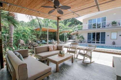 a patio with a couch and chairs and a table at Tamarindo Bay Boutique Hotel, Apartments & Suites in Tamarindo