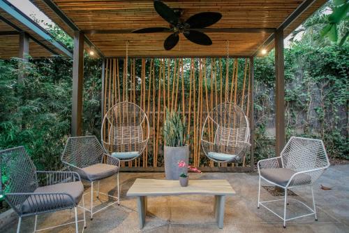 a patio with chairs and a table and a ceiling fan at Tamarindo Bay Boutique Hotel, Apartments & Suites in Tamarindo