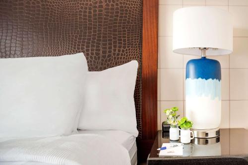 a bed with a blue lamp on a table next to it at Hotel Lulu, BW Premier Collection in Anaheim