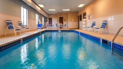 a swimming pool with chairs and chairs in a building at Best Western Port Huron Blue Water Bridge in Port Huron