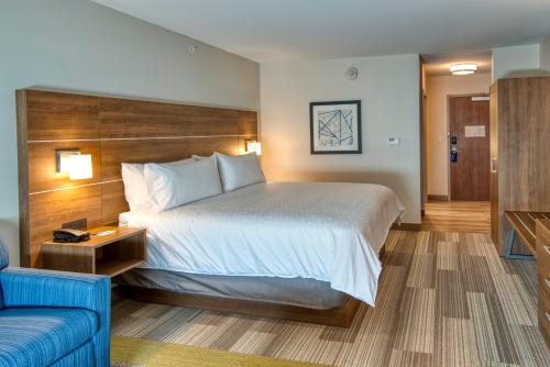 a hotel room with a bed and a blue couch at Holiday Inn Express & Suites - Omaha Downtown - Airport, an IHG Hotel in Omaha