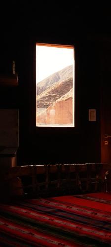 a window in a dark room with a large rug at Tierra Quebrada Cabañas in Purmamarca