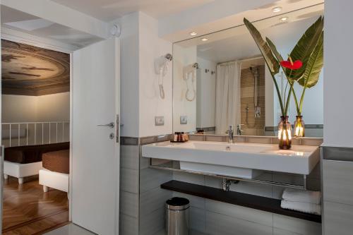 une salle de bain avec un lavabo et un miroir dans l'établissement DVE Suite Rome, à Rome