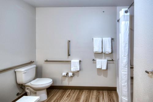 a bathroom with a toilet and towels on the wall at Holiday Inn Express & Suites Omaha Downtown Old Market by IHG in Omaha
