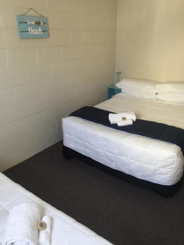 a room with two beds with towels on them at Whitianga Motel in Whitianga