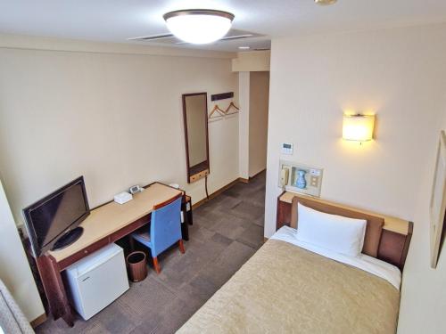 a room with a bed and a desk with a computer at Kadoma Public Hotel/ Vacation STAY 33571 in Kadoma