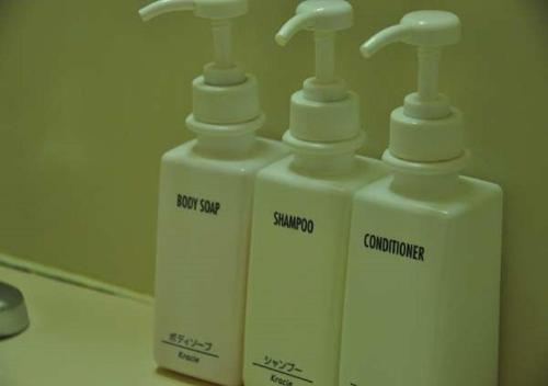 two white soap dispensers sitting on top of a counter at Kadoma Public Hotel/ Vacation STAY 33574 in Kadoma