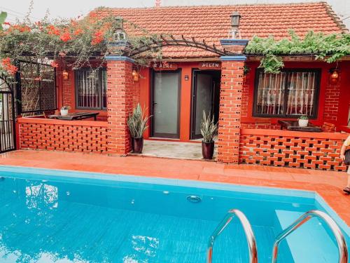 a house with a swimming pool in front of it at Vu's Homestay in Phong Nha