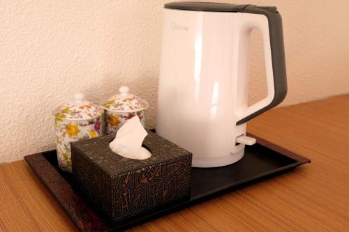 a coffee maker and a box on a shelf at Gaisang Mêdog Aroma Fragrance Hotel in Lhasa