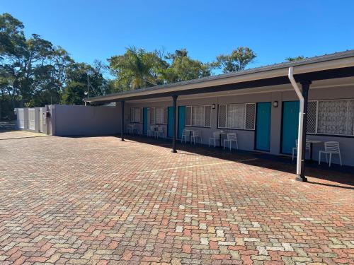 a building with a red brick driveway in front of it at Hervey Bay Motel in Hervey Bay