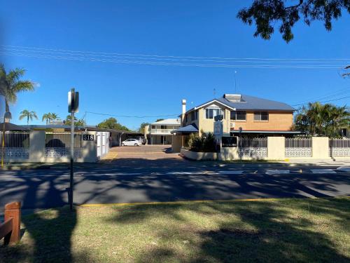 a street with a house and a fence at Hervey Bay Motel in Hervey Bay