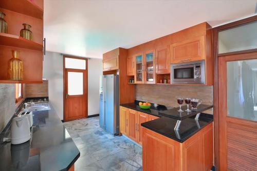 a kitchen with wooden cabinets and a blue refrigerator at Siam Pool Villa Pattaya in Pattaya South