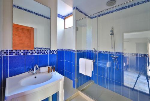 a blue tiled bathroom with a sink and a shower at Siam Pool Villa Pattaya in Pattaya South