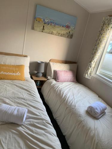 2 letti posti uno accanto all'altro in una camera da letto di Bliss Beach Lodge a Bembridge