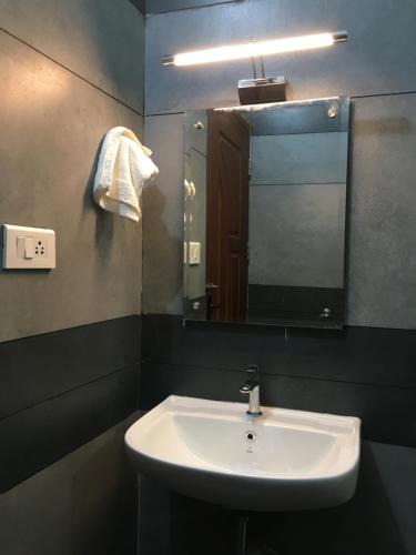 ein Bad mit einem Waschbecken und einem Spiegel in der Unterkunft Vagamon Vagashore in Vagamon