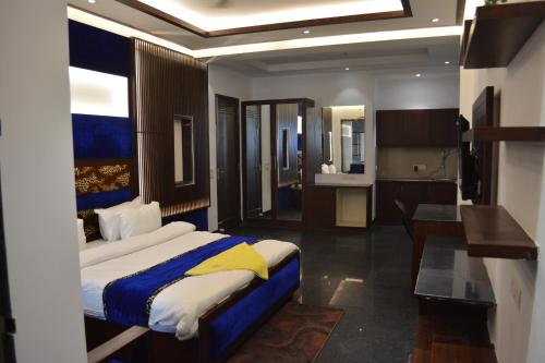 a bedroom with a large bed and a kitchen at JJK Rukmini Vilas Hotel & Banquet in Muzaffarpur