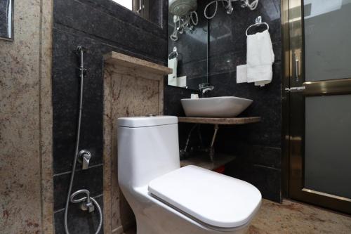 a bathroom with a toilet and a sink at JJK Rukmini Vilas Hotel & Banquet in Muzaffarpur