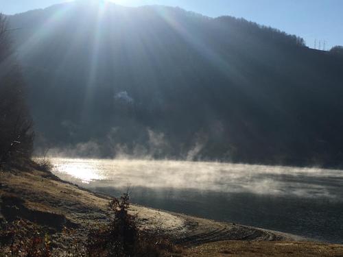 a body of water with the sun shining on it at Luxury Lake House & Glamping in Teşila