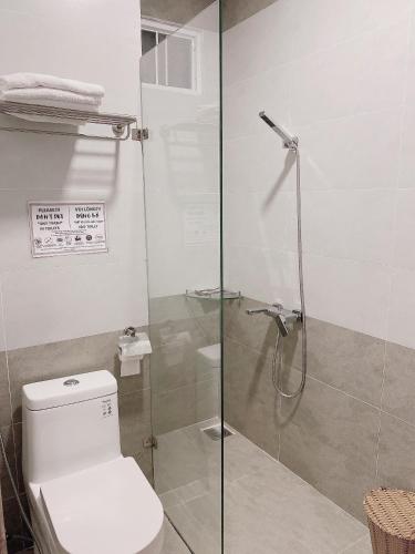 a bathroom with a toilet and a glass shower at Tuyet Son Hotel in Da Lat