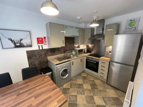 una cocina con lavadora y mesa. en Foxglove Apartment, en Inverness