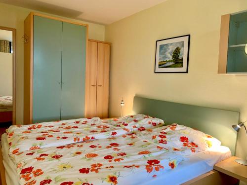 a bedroom with a large bed with flowers on it at de Bülk in Dorum Neufeld