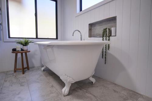 a white bath tub with a sink in a bathroom at Amaroo Escape in Coneac