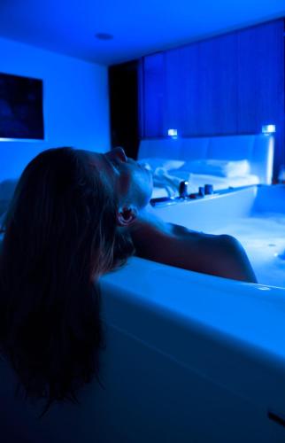 a woman laying on a bed in a room with blue lights at Villa EVA in Dobrovo