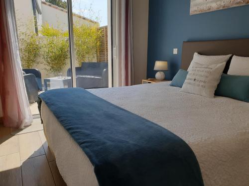 a bedroom with a large bed and a large window at Le Temps d'une Pause in Bretignolles-sur-Mer