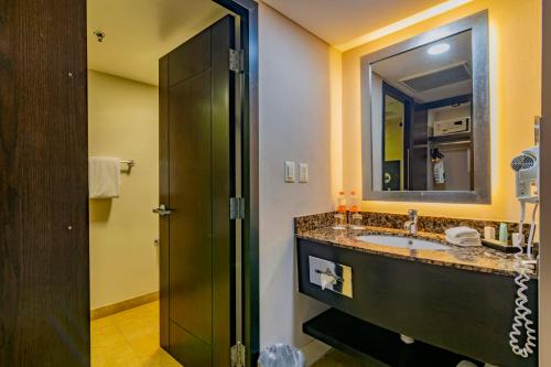 a bathroom with a sink and a mirror at Hotel Lucerna Hermosillo in Hermosillo