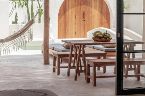 a table and chairs with a bowl of fruit on it at YUCCA villas in Canggu