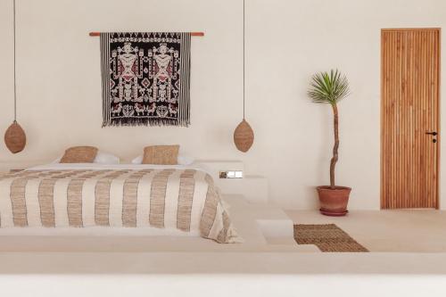 a bedroom with a bed and a potted plant at YUCCA villas in Canggu