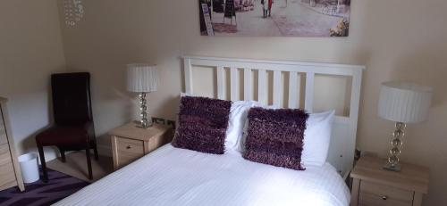 a bedroom with a white bed with two lamps and a speaker at Canal Side in Worcester