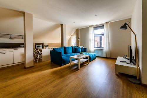 a living room with a blue couch and a table at Liepaja Apartments Downtown in Liepāja