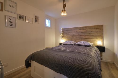 une chambre avec un grand lit avec une tête de lit en bois dans l'établissement Jules - appartement au calme dans la BASTIDE proche citée médiéval, à Carcassonne