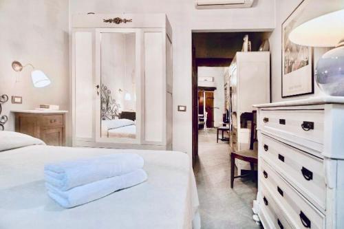 Habitación blanca con cama blanca y baño. en Una Terrazza nel Centro Storico, en Barga
