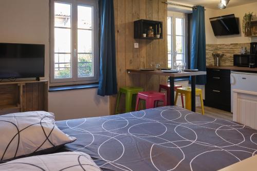 une chambre avec un lit et une cuisine avec une table dans l'établissement Jules - appartement au calme dans la BASTIDE proche citée médiéval, à Carcassonne