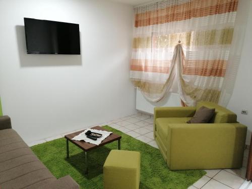 a living room with a green couch and a tv at Fast Sleep & Go 1 in Paraćin