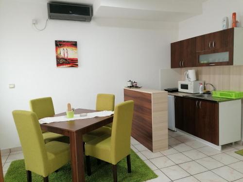 a kitchen with a table and yellow chairs in a kitchen at Fast Sleep & Go 1 in Paraćin