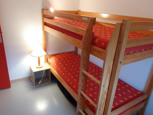 a bedroom with two bunk beds with a lamp at Gîte du Gua des Brasses au bord du lac de la Raviège in La Salvetat