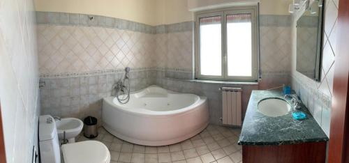 a bathroom with a tub and a toilet and a sink at I Cardellini in Mascali