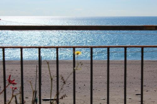 a fence on the beach with the ocean in the background at I Cardellini in Mascali
