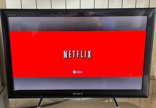 una pantalla de televisión con el signo netflix en ella en La Croix du Sud, en Le Touquet-Paris-Plage