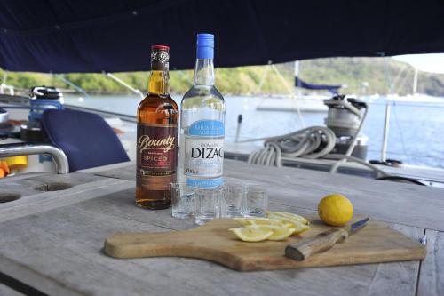 a bottle of wine and glasses on a wooden table at THE BAHI VILLA - Adults Only B&B in Les Trois-Îlets