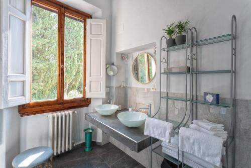 a bathroom with two sinks and a window at Villa La Petraia in Panzano