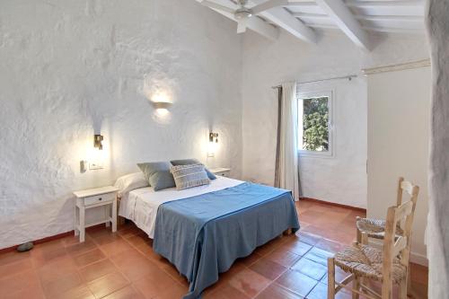 a bedroom with a bed and a table and a window at Son Camaro in Ciutadella